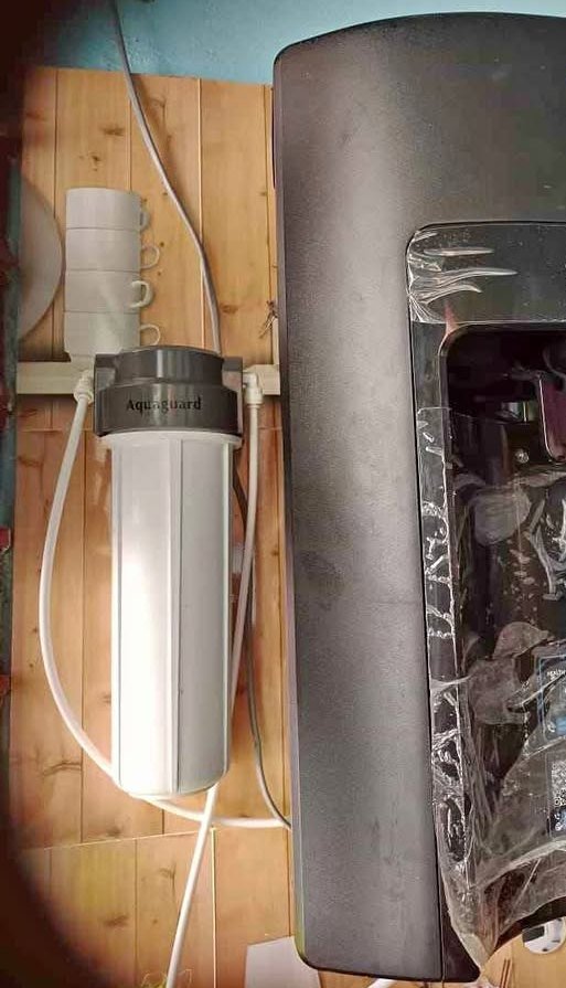 Aquaguard Sure Delight 2X RO water purifier setup showing the external pre filter housing and connected inlet water pipe