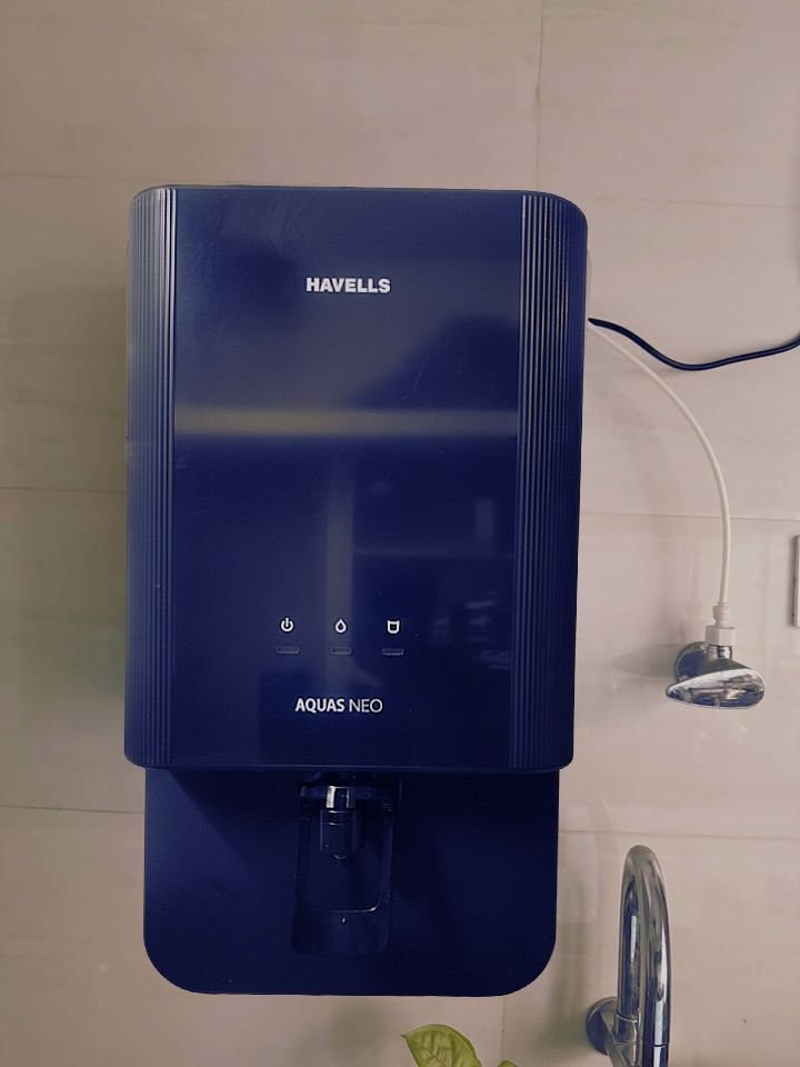 Havells Aquas Neo water purifier wall mounted installation in kitchen, showing power connection and water inlet near sink tap