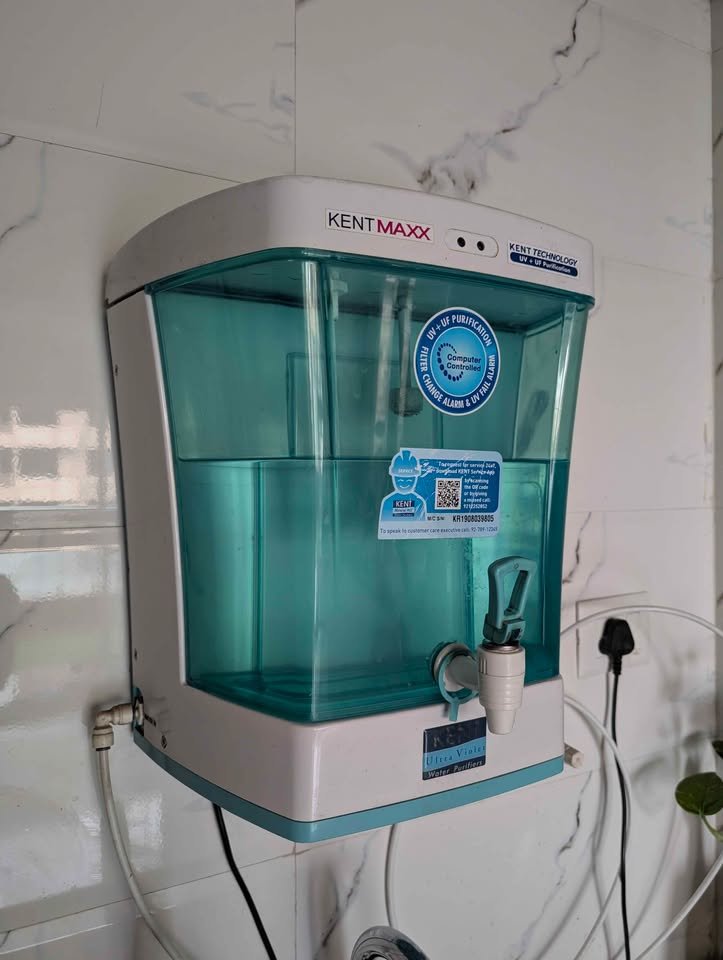 Close-up of KENT Maxx UV and UF water purifier showing transparent tank design and front dispenser tap