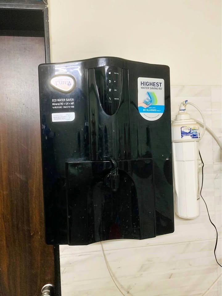 Wall-mounted Pureit Eco Water Saver RO+UV+MF water purifier installation with pre-filter beside unit