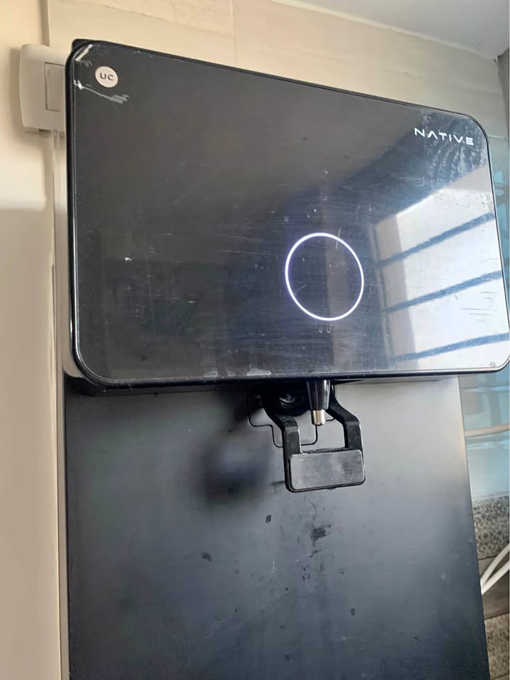 Close-up of the UC Native M1 RO purifier tap showing the dispensing spout on the front panel during installation